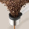 Close-up of fresh ground beans being processed inside the Philips Baristina Combo Espresso Machine with Milk Frother BAR303/00. The machine's sleek white body contrasts beautifully with its stainless steel and black components as ground coffee exits through a spout below. The beige background sets the stage for barista-quality espresso.