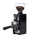 The Eureka Mignon Libra 65 All Purpose Grinder, presented in an elegant black finish, includes a transparent hopper for coffee beans. It features an electronic display and a portafilter cradle, along with precise grind size adjustments enabled by its flat burr set for optimal brewing outcomes.