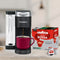 A Keurig coffee maker brews rich coffee using Lavazza Qualità Rossa K-Cup® Pods, an Arabica and Robusta blend. The red mug sits elegantly on the light gray kitchen counter, promising a delightful experience.