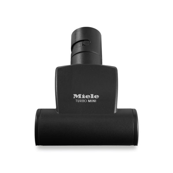 The Miele Handy TurboBrush Vacuum Cleaner Attachment STB 101 is a black, eco-friendly upholstery nozzle featuring a cylindrical design and the Miele logo on the front, suitable for use with various vacuum cleaners.