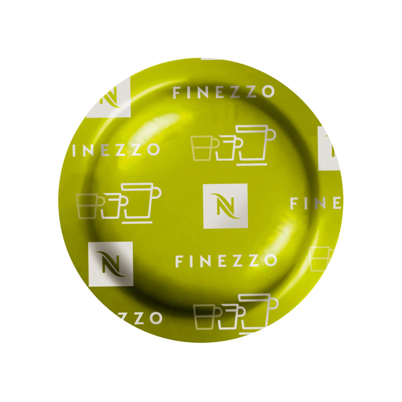 A Nespresso Espresso Finezzo Professional Capsule, part of a box of 50, displays "Finezzo" text and white cup icons against its green surface. This design highlights its circular, smooth shape when viewed from above and suggests the floral aromas of the delightful Arabica blend contained within.