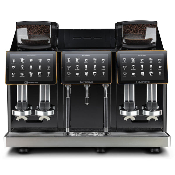 Front view of the Eversys Shotmaster 4 Group Head Steam Wand Pro Super Traditional Espresso Machine s-pro/ST (Charcoal), showcasing its dual bean hoppers on top, digital touchscreen controls, and dispensing nozzles for coffee and steamed milk. Featuring a built-in milk module and steam wand with Everfoam technology, this predominantly black and stainless steel machine is capable of producing up to 700 espressos per hour.