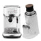 The Black Friday Bundle from Breville features The Bambino Plus Espresso Machine in Sea Salt and the stylish DF64 Gen 2 Grinder with DLC Burrs in White. The Bambino Plus includes a steam wand, while the grinder is equipped with a portafilter holder. Both items possess a modern design that enhances any kitchen decor.