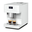 The Miele CM6160 Milk Perfection Countertop Coffee Machine in Lotus White boasts a modern design that allows it to brew two cups of espresso simultaneously. Customize your coffee experience using the user profiles, with ease of operation provided by its digital display and multiple function buttons, as the dual spouts dispense coffee into clear glass cups placed on its drip tray.