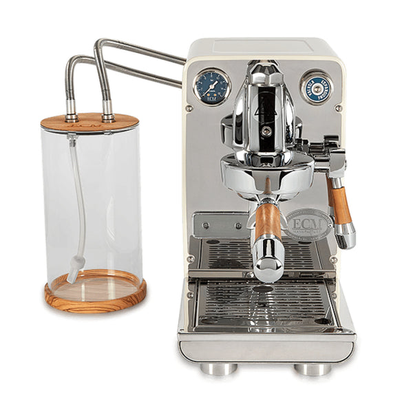 The ECM Puristika Semi Automatic Espresso Machine in cream color, by ECM, showcases a modern design with wooden accents. It features an E61 group head and a steam wand. The espresso machine includes a pressure gauge and is equipped with a stainless steel boiler. Accompanying it is a transparent water tank accented with wooden top and bottom, connected seamlessly by thin metal tubes.