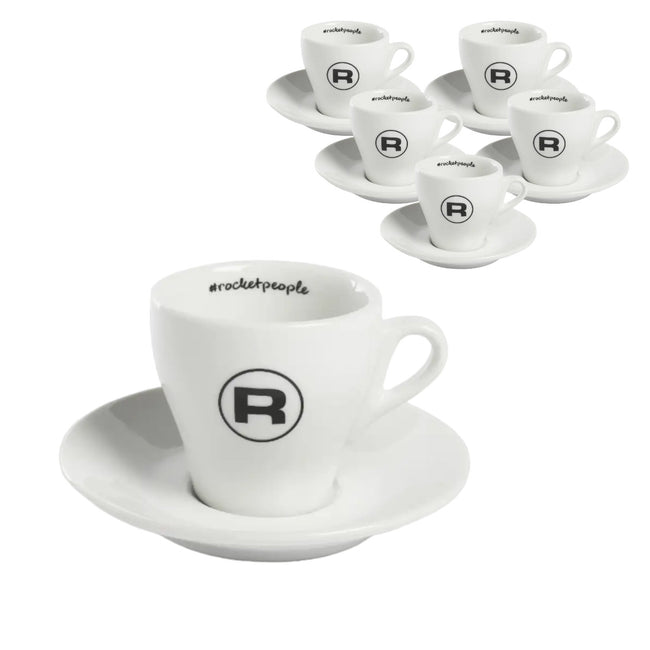 The Rocket Espresso Cups Hashtag Series - Set of 6 RA99907206 (White) includes two ceramic espresso cups with saucers, each adorned with the letter "R" inside a circle. One set is white and the other is black. These Rocket Espresso cups feature small handles, with the branding "