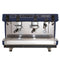 The FAEMA Prestige Plus 2 Group Head Tall Cup Autosteam Espresso Machine F01-UQ210T2BTDDGA in Indigo Blue features two group heads, steam wands, a hot water outlet, and a pressure gauge. It showcases an elegant blue and stainless steel design with the "Faema PRESTIGE" label on the upper right corner. The machine includes an advanced thermal system with adjustable temperature controls for precise brewing.