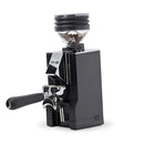 Introducing the Eureka Mignon Zero 65 All Purpose Grinder (Black) by Eureka: a stylish coffee grinder featuring a transparent hopper filled with coffee beans. It comes with a handle for manual operation and showcases an angular design. Equipped with an all-purpose burr system, it guarantees minimal retention for the freshest and most flavorful grind every time.