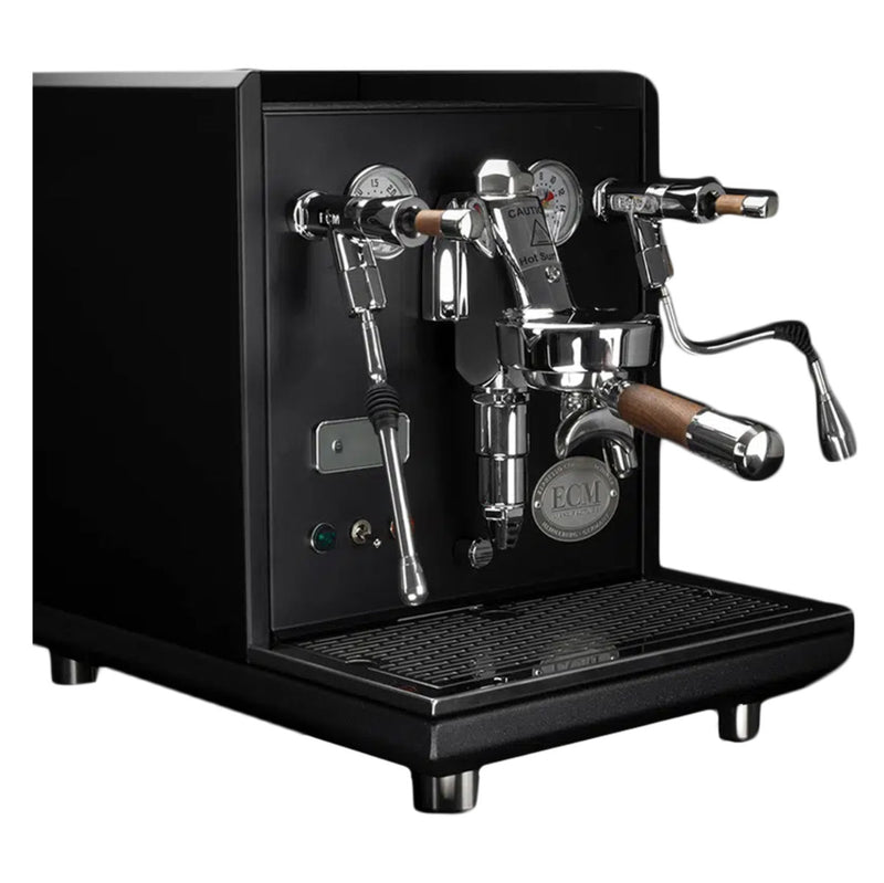 The ECM Synchronika Espresso Machine - Dual Boiler w/ PID and Flow Control (Black) by ECM features a sleek, black design with polished metallic components. It boasts dual pressure gauges, wooden handles on the steam wand and portafilter, an ECM branded badge on the front, an E61 Group Head, and a conveniently located drip tray at the base.