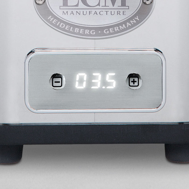 A close-up shot of the ECM S-Automatik 64 Burr Grinder's display showcases the number "03.5," flanked by plus and minus buttons for precise coffee dosing adjustments. The label above proudly states, "ECM Manufacture Heidelberg, Germany," reflecting a commitment to excellence in freshly ground coffee.