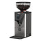 Introducing the Gaggia MDF 55 Grinder, a sleek stainless steel coffee grinder equipped with Silent-Grind Technology and a transparent bean hopper filled with coffee beans on top. This premium grinder from Gaggia features a digital display with buttons for controlling stepless micrometric adjustments and includes a portafilter holder beneath the dispensing chute.