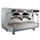 A white FAEMA E98UP 2 Group Head Espresso Machine (model F01-UL210VWTB999A) boasts an ergonomic and robust design. The sleek, modern machine features a branded logo on the front, control knobs for brewing settings, and a fixed-nozzle thermosyphon system, all placed on a reflective surface. Steam wands are conveniently located on either side of this stylish espresso machine.