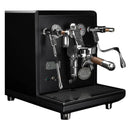 The ECM Synchronika Espresso Machine - Dual Boiler w/ PID (Black) (Special Edition) by ECM is a sleek, black espresso machine with chrome accents, featuring dual gauges, an E61 Group Head portafilter, and a steam wand. The machine also boasts wooden handles and buttons, alongside a drip tray and a branded medallion on the front.