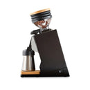 Side view of the Eureka Oro Mignon Single Dose Pro Grinder (Black) showcasing its modern design with flat burrs and a transparent bean hopper on top. The elegant black body features wooden base details and contains a grind chamber engineered for zero-retention, paired with a stainless steel carafe below.