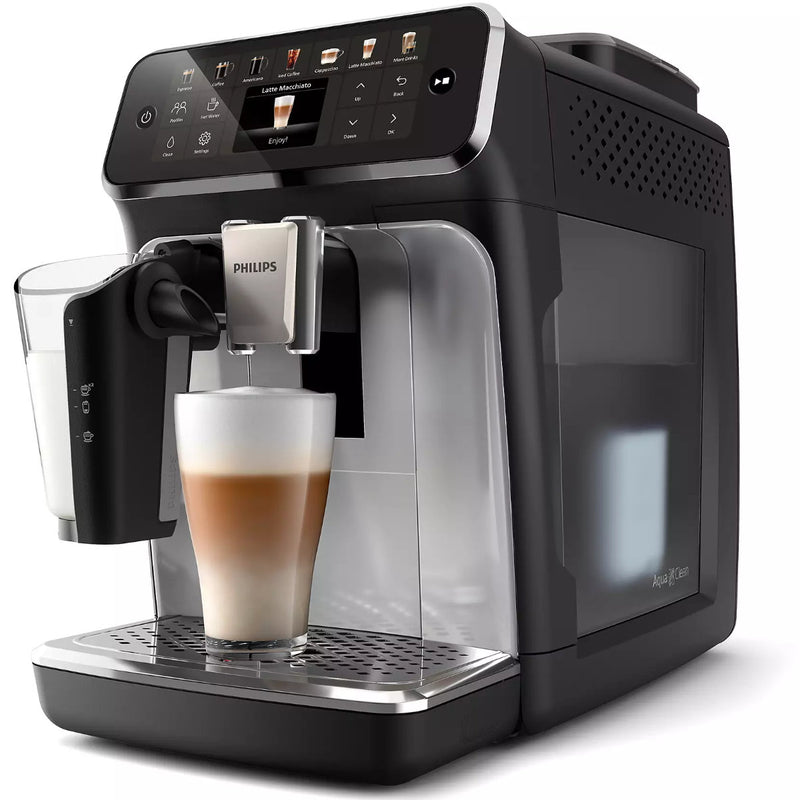 A sleek Philips 4400 LatteGo Super Automatic Espresso, Cappuccino, & Latte Macchiato Machine with SilentBrew EP4447/90 in black is making a cup of frothy latte. Featuring SilentBrew technology, the machine has a digital display and various control buttons on its front panel. A milk frother is attached to the side, dispensing coffee into a transparent glass on the drip tray.