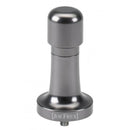 The JoeFrex Technic Calibrated Dynamometric Adjustable Tamper Handle in gunmetal, is displayed. This tamper, featuring JoeFrex's signature grip technology, has a sleek cylindrical handle and a flat base. Predominantly silver in hue, it is elegantly engraved with the brand name "JoeFrex" at the base.