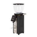 The Profitec Twist A54 Coffee Grinder features a sleek design with a transparent hopper, black base, and digital display. It includes durable stainless steel accents with "TWIST" on the front, along with a small lever and power switch.