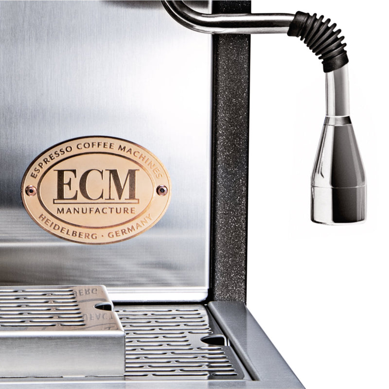 Close-up of an ECM Synchronika Espresso Machine - Dual Boiler w/ PID and Flow Control (Heritage Edition) - PREORDER, featuring the metal "ECM Manufacture" label. The image highlights the steam wand and drip tray, emphasizing its dual boiler for precise brewing.