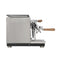 Side view of the Profitec Jump Heat Exchanger Espresso Machine with a stainless steel body and wooden handles on the portafilter and steam wand knobs. It showcases a modern design with a discreet display, sleek finish, and rests on four small legs.