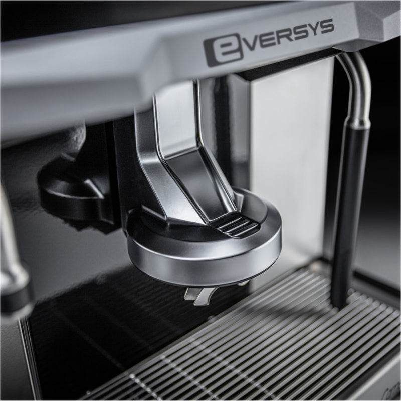 Close-up view of the Eversys Cameo Steam Wand Classic Espresso Machine C'2s (Tempest) highlighting the portafilter holder and drip tray. The sleek black and stainless-steel design, complemented by a powerful steam boiler, emphasizes its modern and industrial style, perfect for creating Latte Art.