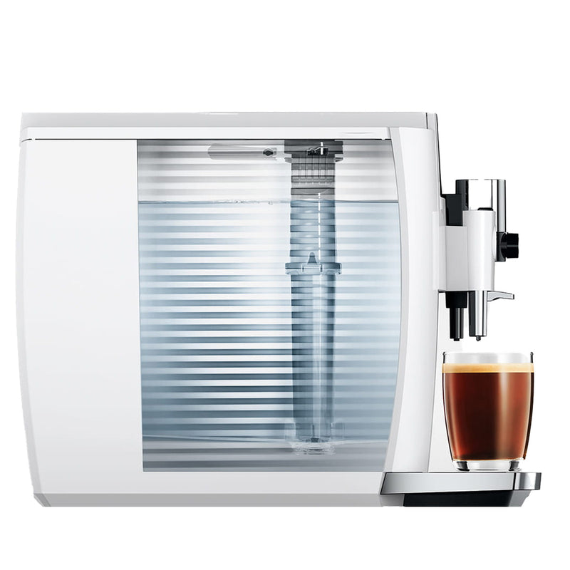 Introducing the latest version of the JURA E8 Piano White Automatic Coffee Machine 15683, a modern marvel with a sleek design. It features an elegantly transparent, ribbed water reservoir on the side and leverages advanced brewing technology to deliver barista-quality coffee. A small cup of freshly brewed espresso sits on the drip tray, ready to be savored.