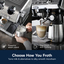 A split image features an individual steaming milk using the DeLonghi La Specialista Maestro Espresso Machine with Cold Brew EC9885M in Silver. On the left, a "Powerful steam wand" crafts microfoam, while on the right, "One-touch auto frothing" prepares a cappuccino. The text reads: "Choose How You Froth.