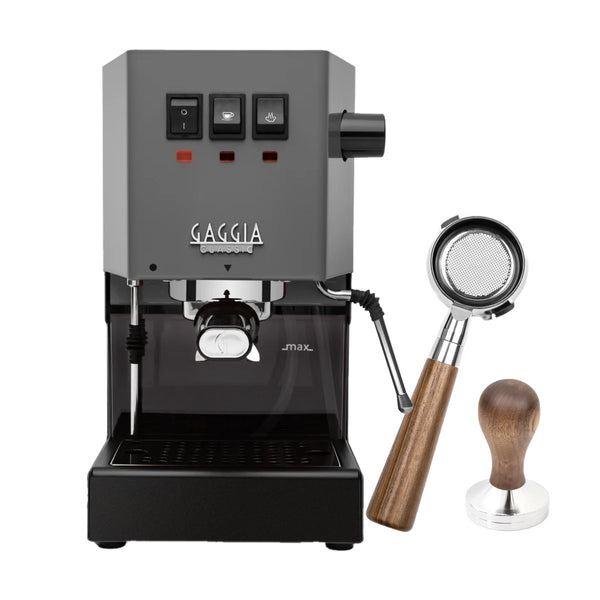 The Gaggia Classic E24 Espresso Machine in grey boasts three intuitive buttons and a steam wand, paired with a bottomless walnut portafilter and tamper bundle, all set against a pristine white background for elegant display.