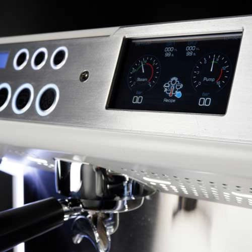 Close-up of the Conti MC Ultima Espresso Machine's digital display and control panel in black. The screen displays gauges for steam and pump, complemented by nearby circular buttons. Boasting adjustable temperature settings, a portafilter is situated below the panel to ensure perfect brewing precision.