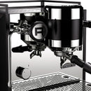 Introducing the Rocket Bicocca Dual Boiler Espresso Machine RE602V3B11 in black, a modern masterpiece that embodies Italian heritage with its sleek design. This artisan espresso machine boasts an ergonomic layout featuring two group heads, a portafilter, and a steam wand. Its glossy finish is accentuated by the distinctive "R" logo on the side. Available for preorder now!