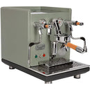 The ECM Synchronika Espresso Machine - Dual Boiler w/ PID (Special Edition Cement Grey) is a sleek model featuring wooden handles, dual steam wands, and pressure gauges. Its front panel includes a lever, switches, and indicator lights. This compact espresso machine also boasts an E61 Group Head and includes a drip tray below the brewing area.