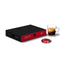 A box of Nespresso Decaffeinato Professional Capsules (Box of 50) rests on a white surface, accompanied by a filled glass coffee cup and a single red pod. The sleek black box with red accents promises an aromatic intensity in every decaffeinated coffee serving. The cup features a small black label at its base.