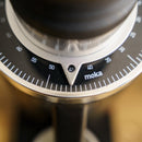 Close-up of a DF64 Gen 2 Single Dose Coffee Grinder With DLC Burrs (Black) - Open Box, Unused by DF Grinders. The dial is set at the 45 mark for fineness, featuring clear numerical indicators and a stylish, modern design with the word "moka" prominently displayed. Equipped with 64mm DLC burrs for zero retention grinding, the numbers on the dial range from 30 to 65.