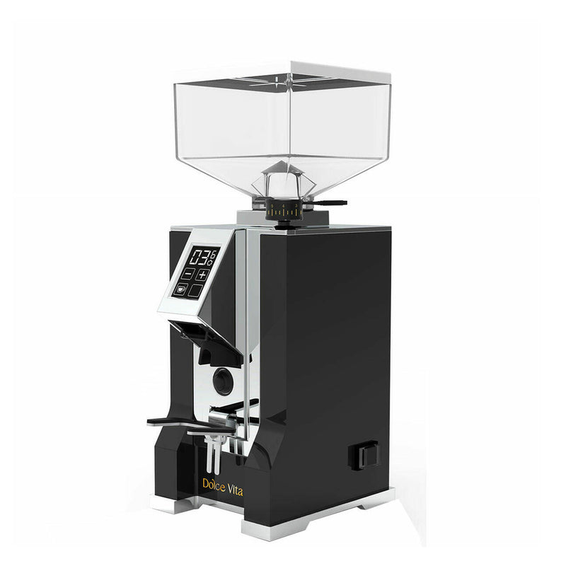 The Eureka Oro Mignon Dolce Vita (Matte Black) electric coffee grinder is showcased with a clear, square-shaped bean hopper on top. It features a digital display and controls on the front, equipped with Pure Diamond Burrs and Silent Technology for a seamless grind. The brand name "Eureka" is printed on the lower part of the grinder.