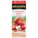 A box of Bigelow Cinnamon Apple Tea Bags. The packaging showcases a basket brimming with red apples, both whole and halved, set on a wooden surface. This naturally fruit-infused tea offers 28 caffeine-free bags for your enjoyment.