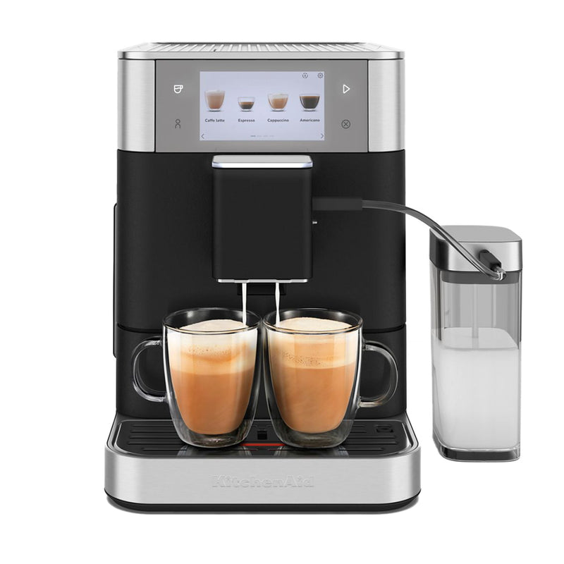 The KitchenAid KF8 Fully Automatic Espresso Machine (Cast Iron Black) KES8558BK is a stainless steel and black appliance that brews two cups of barista-quality coffee through its digital interface. It features several buttons for customizable coffee recipes and includes a milk frother with a clear container of milk on the side.