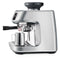 The Breville Oracle Jet Espresso Machine BES985BSS, crafted in brushed stainless steel by Breville, features a modern design with a milk frothing wand and digital display. This advanced machine delivers commercial-level performance through its sophisticated automation. The product is displayed at an angle, with a metal frothing jug positioned under the wand on the drip tray.