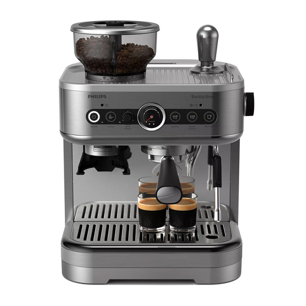 The Philips Barista Brew Semi Automatic Espresso Machine with Dual Bean Hopper PSA3228/01 (Silver) by Philips features a stainless steel finish, a dual bean container, top-mounted built-in grinder, various control buttons, and a steam wand. Four small glasses filled with coffee sit on the drip tray beneath the brew head.