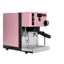 A Rancilio Silvia Pro X Dual Boiler Espresso Machine with PID in pink, accented with black and silver, showcases dual boilers, multiple buttons, a steam wand, a portafilter, and a pressure gauge. The brand name "Rancilio" is prominently displayed on the front to ensure professional performance. The machine stands against a white background.