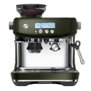 A Breville The Barista Pro Espresso Machine BES878OLT in Olive Tapenade, featuring a digital display with icons and numbers, two espresso spouts, a built-in grinder on top filled with coffee beans, and a steam wand on the right side. This machine includes the ThermoJet heating system and various buttons for settings.