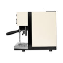 A profile view of the Rancilio Silvia Pro X Dual Boiler and Rancilio Stile Grinder Bundle in white, showcasing its modern design with black accents. The machine features a portafilter with handle, steam wand, and metal drip tray. The sleek design emphasizes minimalism and functionality. The background is plain white.