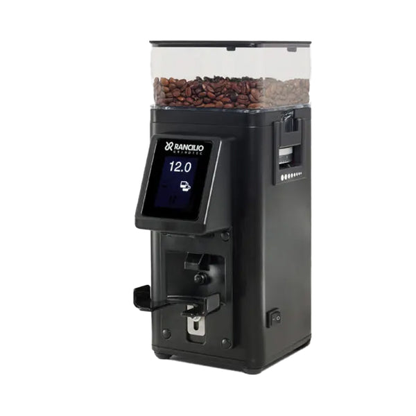 A black Rancilio Stile Espresso Coffee Grinder by Rancilio with a transparent top compartment filled with coffee beans. The grinder features a micrometric adjustment collar and a digital display reading "12.0." Various buttons and slots for operation adorn the front. The unit stands on a white background, ready for action.