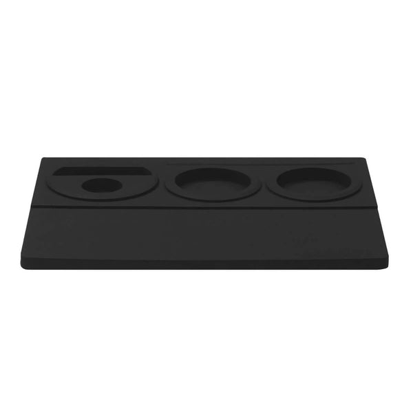 The Normcore Espresso Tamping Station V2 by Normcore is a black silicone desk organizer crafted from durable silicone rubber. It features various circular and oval compartments, ideal for holding small office supplies or personal items. This minimalist rectangular organizer is perfect for those who appreciate streamlined design and functionality, including espresso accessories.