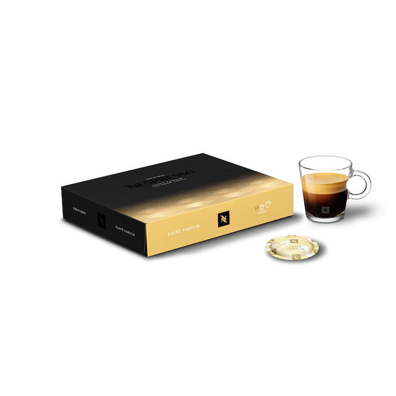 A box of Nespresso Cafe Vanilio Professional Capsules (Box of 50) is displayed next to a transparent glass cup containing a shot of vanilla-infused coffee and a single light-colored capsule. The black and yellow box, along with the capsule labeled "Vanilio," promises a custard-like taste derived from South American Arabica beans.