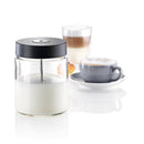 A Miele Glass Milk Container (0.7L) with a black lid containing a white liquid sits in the foreground. In the background, there is a cappuccino in a clear glass with layered froth and a cup of coffee on a saucer, topped with foam. This sleek Miele accessory boasts a 0.7 L capacity, perfect for any Miele coffee machine.