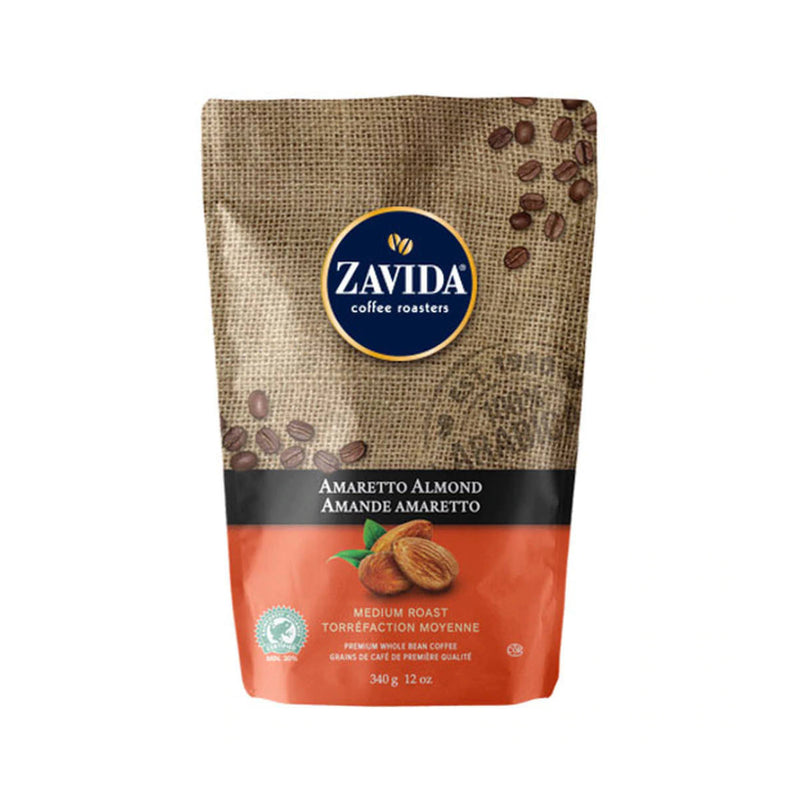 A 12 oz bag of Zavida Amaretto Almond Whole Bean Coffee. This medium roast, 100% Arabica coffee from Zavida features a light burlap pattern with coffee beans and a navy blue Zavida logo, transitioning to a red band at the bottom displaying an image of amaretto and almonds.