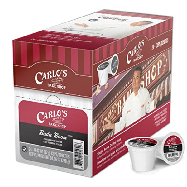 A cardboard box contains 24 single-serve coffee pods labeled "Cake Boss XBold Bada Boom Italian Roast," made from extra bold dark roast coffee. The box features an image of a person in a white chef's jacket with the shop's sign in the background, and includes one coffee pod compatible with K-Cup Brewers placed next to it.